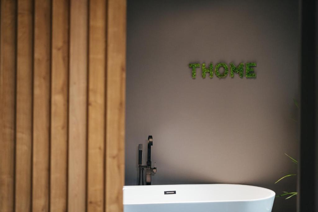 克卢日-纳波卡Thome Arena Residence的带浴缸的浴室和标志,