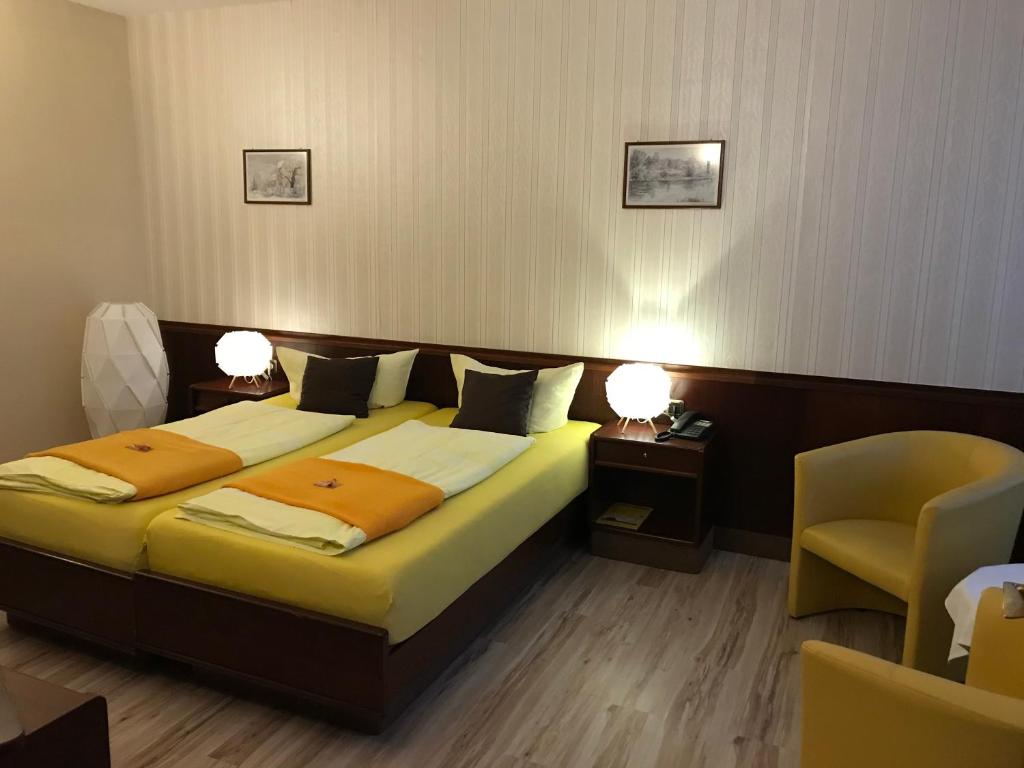 魏森费尔斯斯科恩奥西赫特酒店的一间卧室配有一张床、两盏灯和一把椅子
