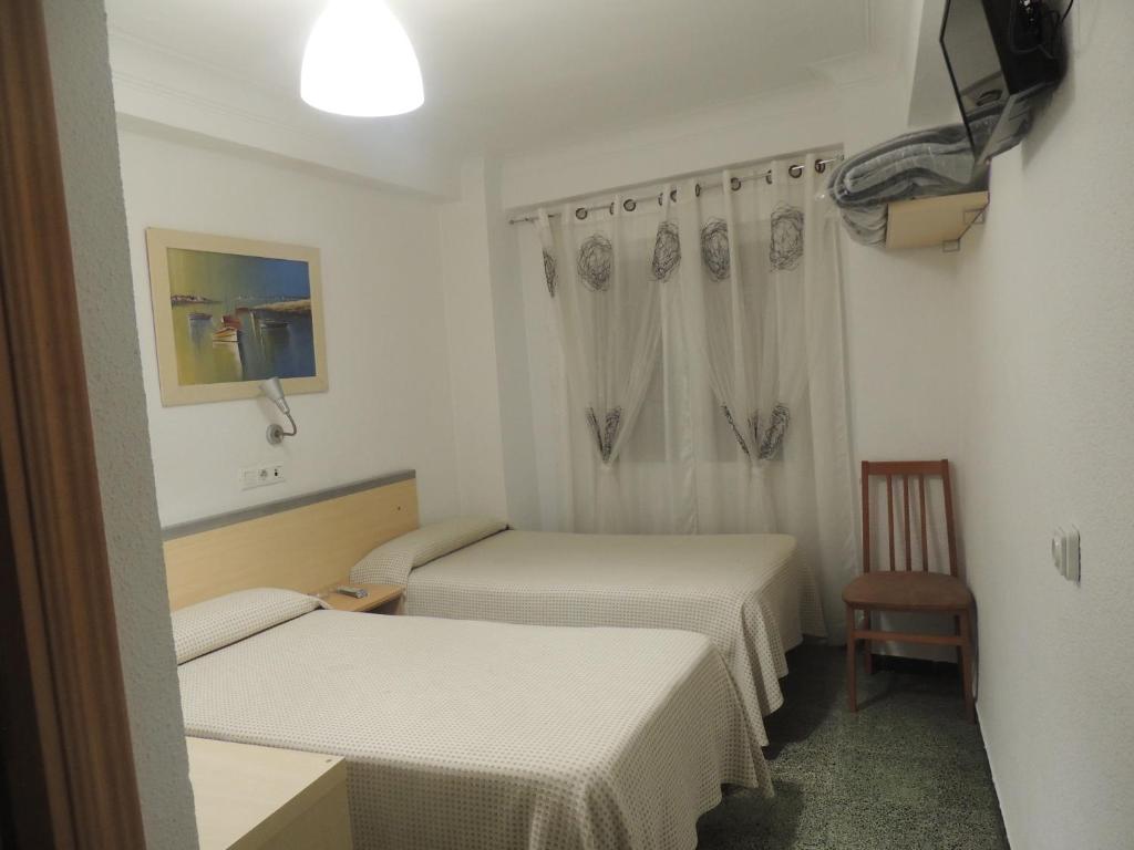 萨拉戈萨康伯利旅馆的小房间设有两张床和椅子