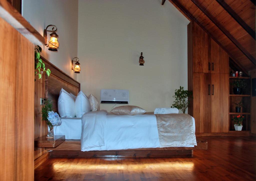 努沃勒埃利耶圣弗朗西斯科度假村的一间卧室配有一张带白色床单的大床