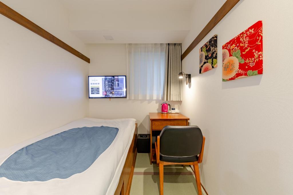 东京The OneFive Tokyo Shibuya的一间卧室配有一张床、一张桌子和一把椅子