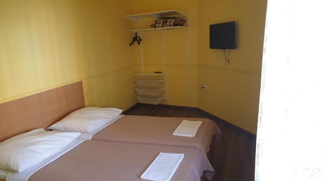 布达佩斯珍玉旅馆的配有黄色墙壁的小客房内的两张床