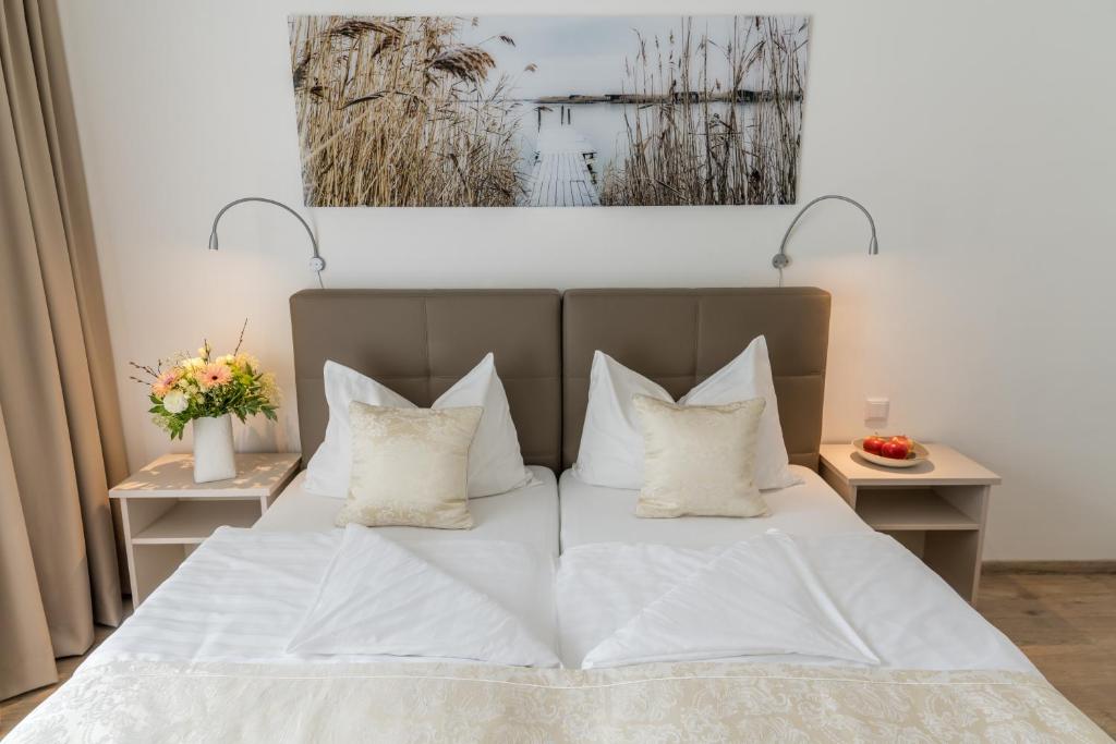 滨湖新锡德尔文德酒店的一间卧室配有带白色床单和枕头的床。