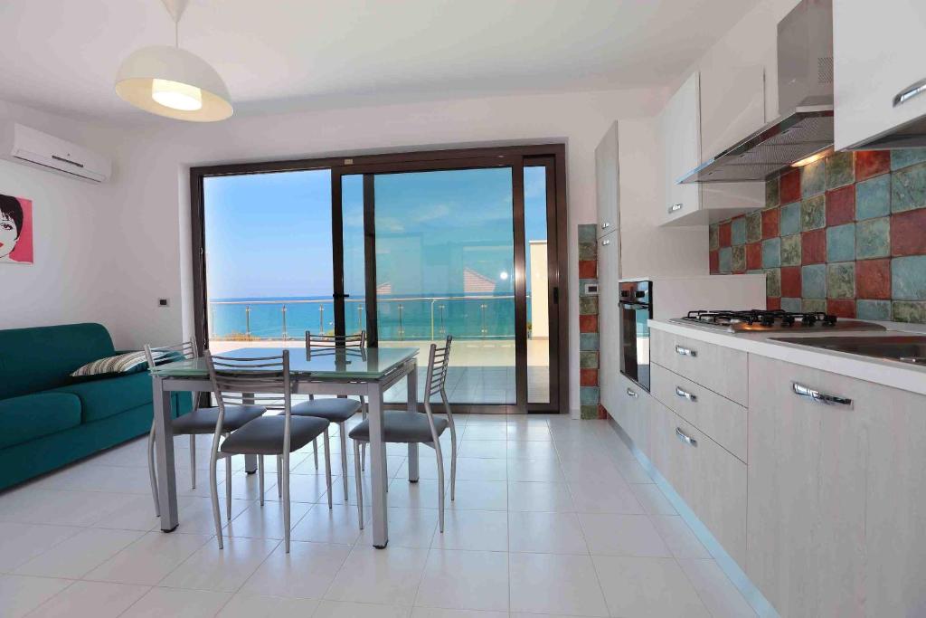 卡普多兰多Il Gabbiano - Case Vacanze的享有海景的厨房,配有桌椅