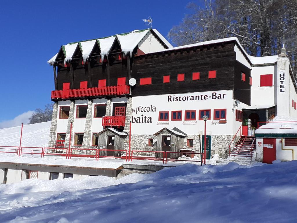 泰尔米尼洛Hotel La Piccola Baita的前方雪地中的一座建筑