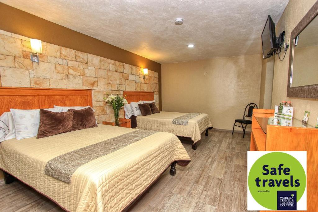 瓜纳华托坎塔多尔大厦酒店的酒店客房设有两张床和石墙。