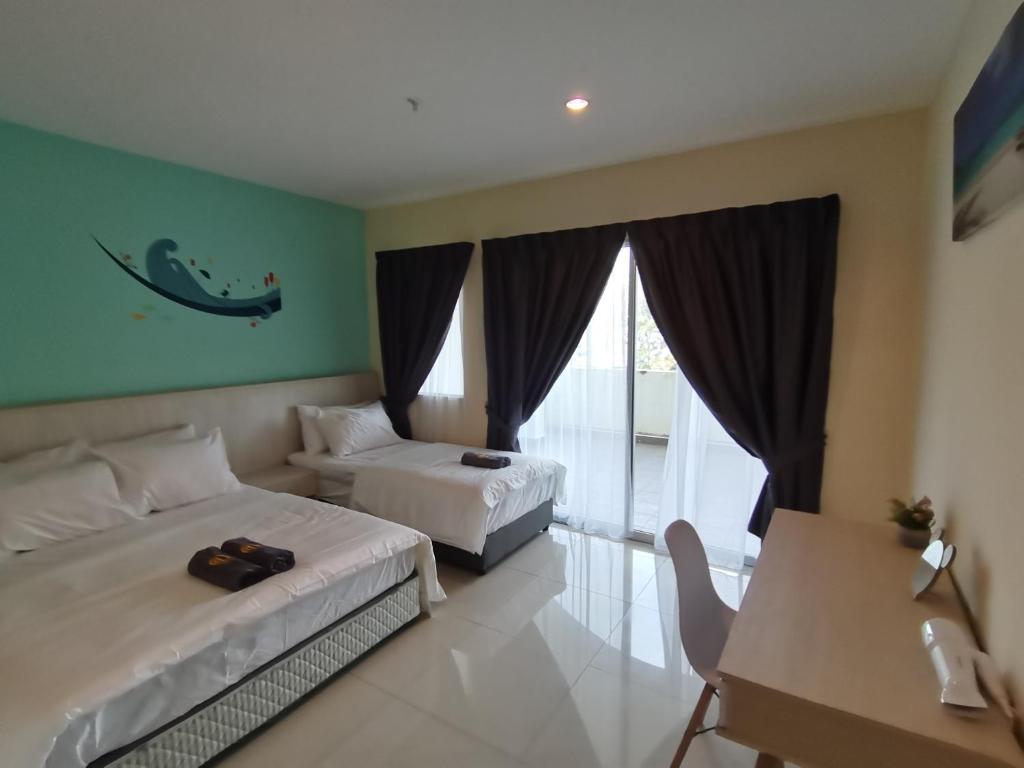 卢穆特Marina Island Lumut Homestay by Goopro的酒店客房设有两张床、一张书桌和一个阳台。
