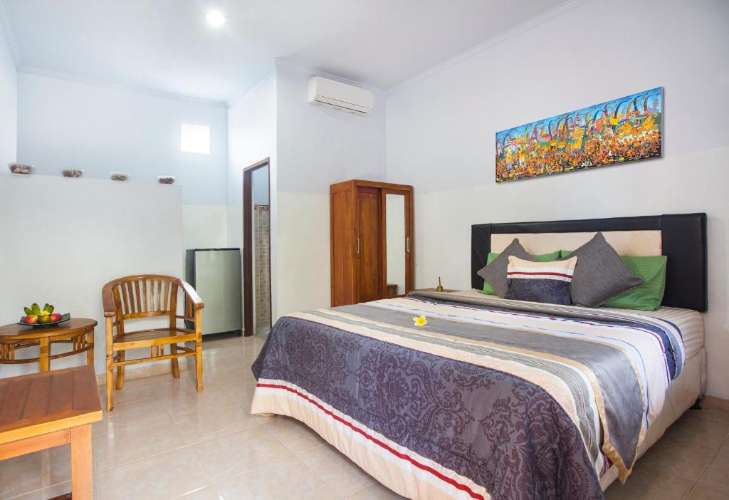 乌鲁瓦图穆拉斯巴莉旅馆的一间卧室配有一张床、一张桌子和一把椅子