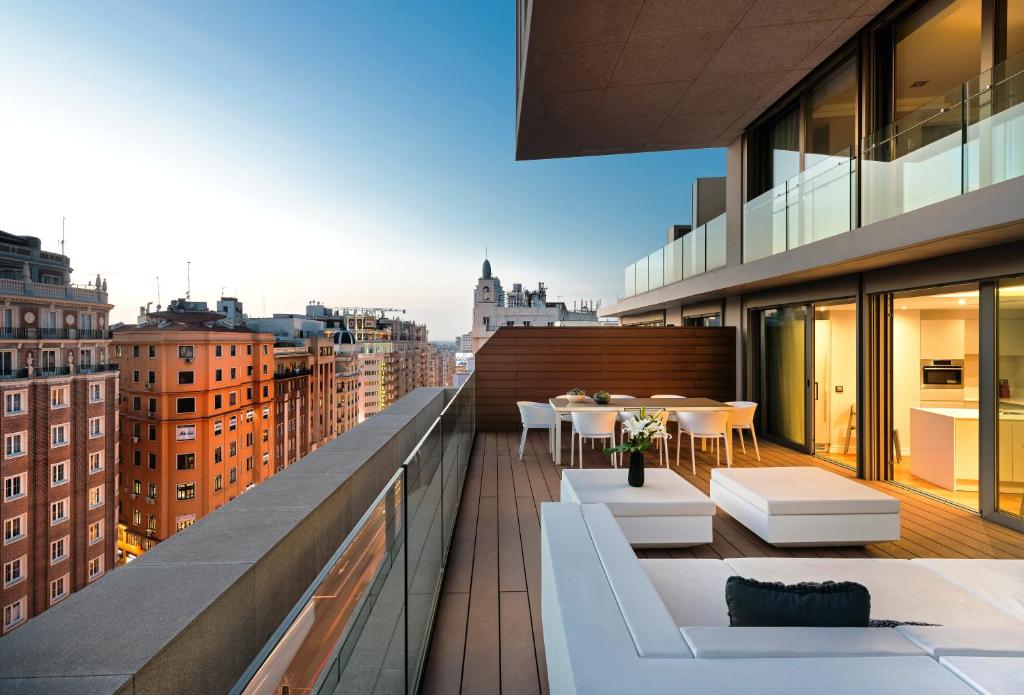 马德里Gran View Apartments的大楼内带桌椅的阳台