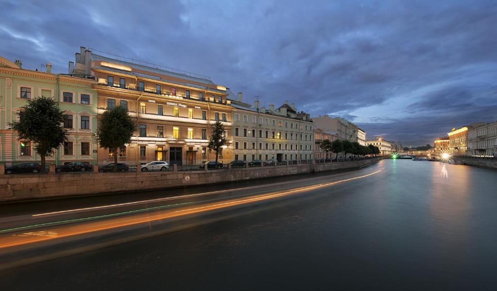 圣彼得堡多米纳圣彼得堡酒店的夜行的城市街道,有建筑和河流