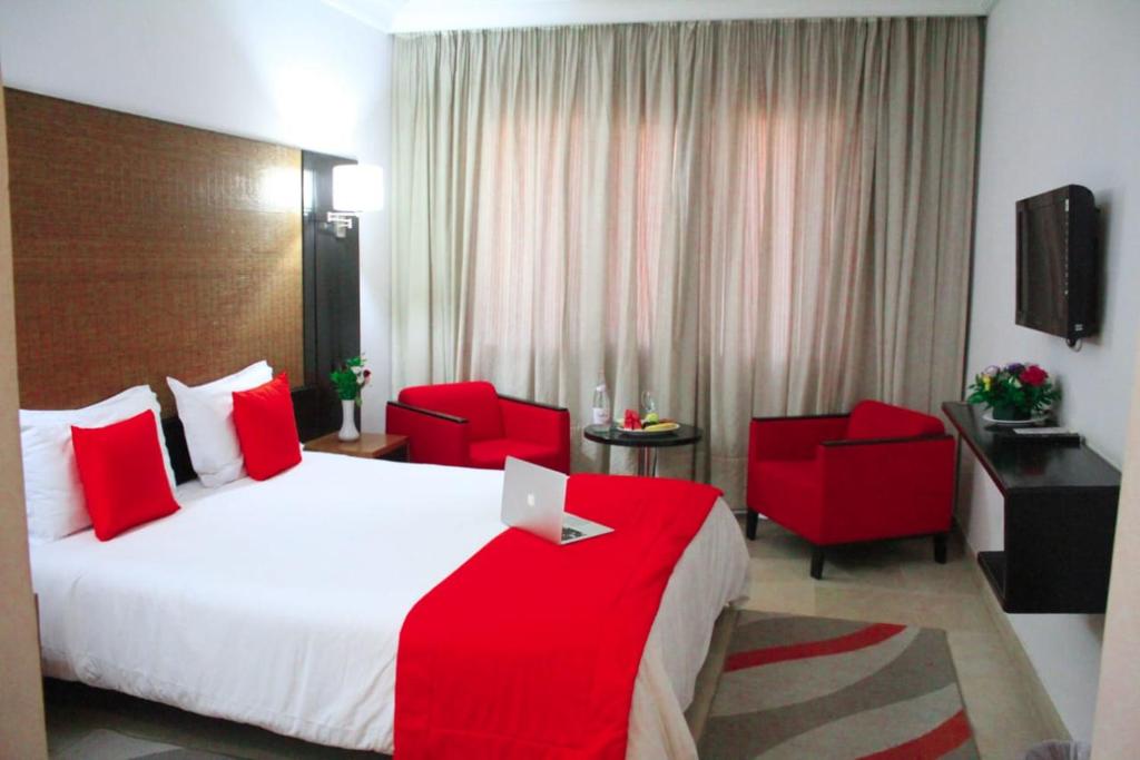 突尼斯hôtel LE PACHA的酒店客房,配有一张床和两张红色椅子