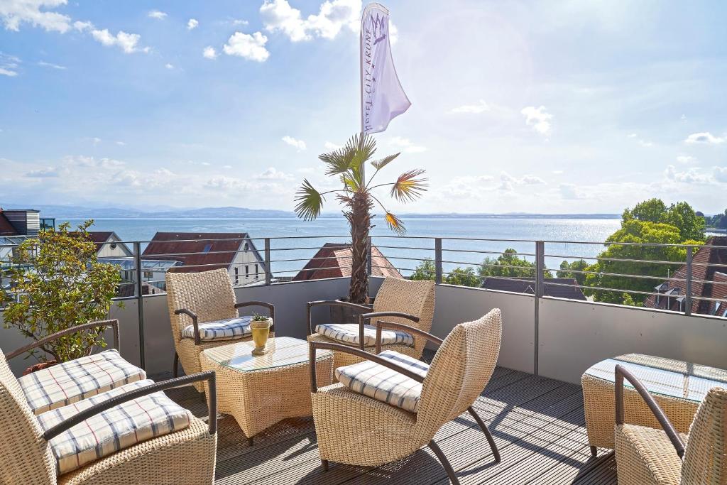 腓特烈港科隆市酒店的阳台配有桌椅,享有海景。