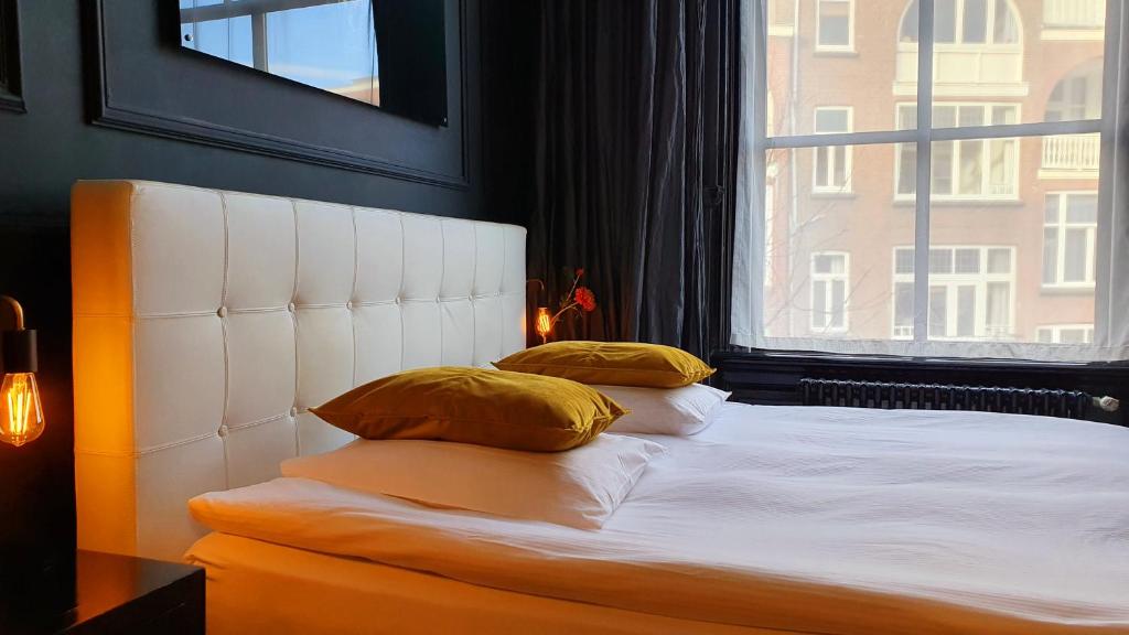 海牙城市住宿旅馆的靠窗的带两个枕头的床