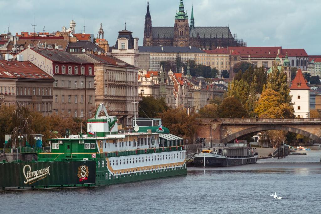 布拉格波特尔海军上将酒店的城市河流上的一艘大型绿色船只