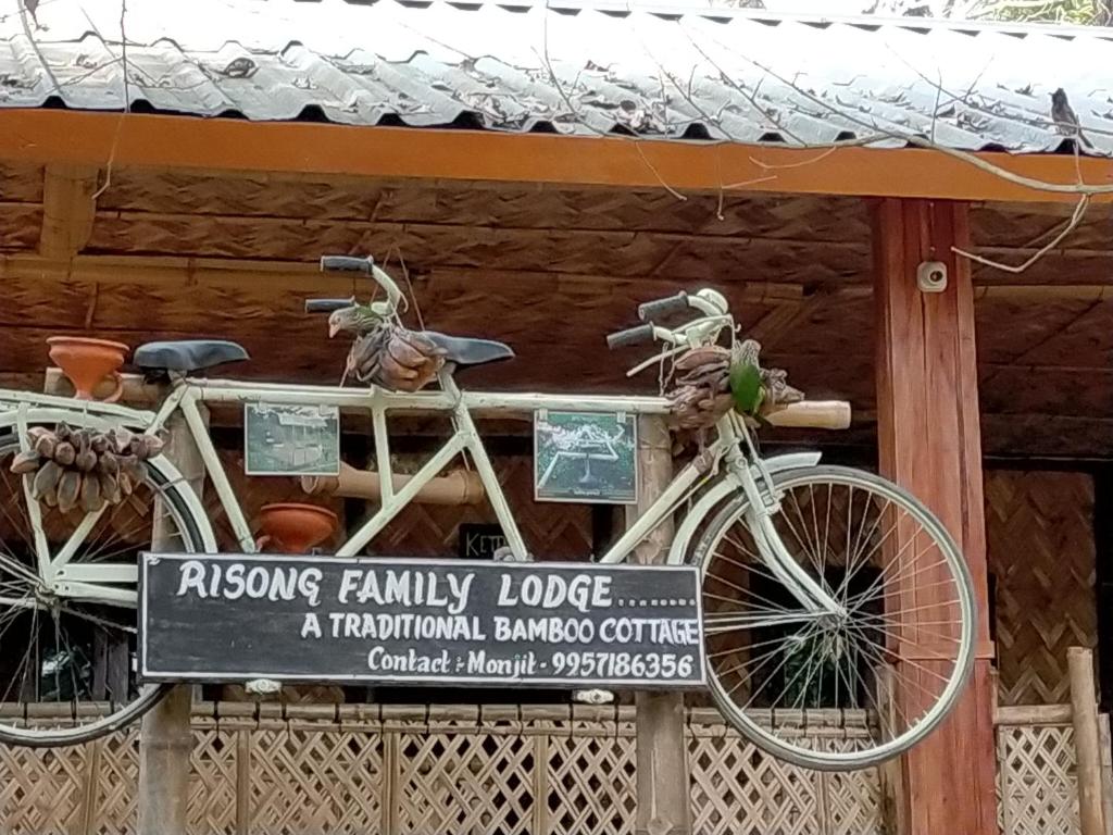 MajuliRisong Family Guest House的两辆自行车被贴在建筑物前面的标志上