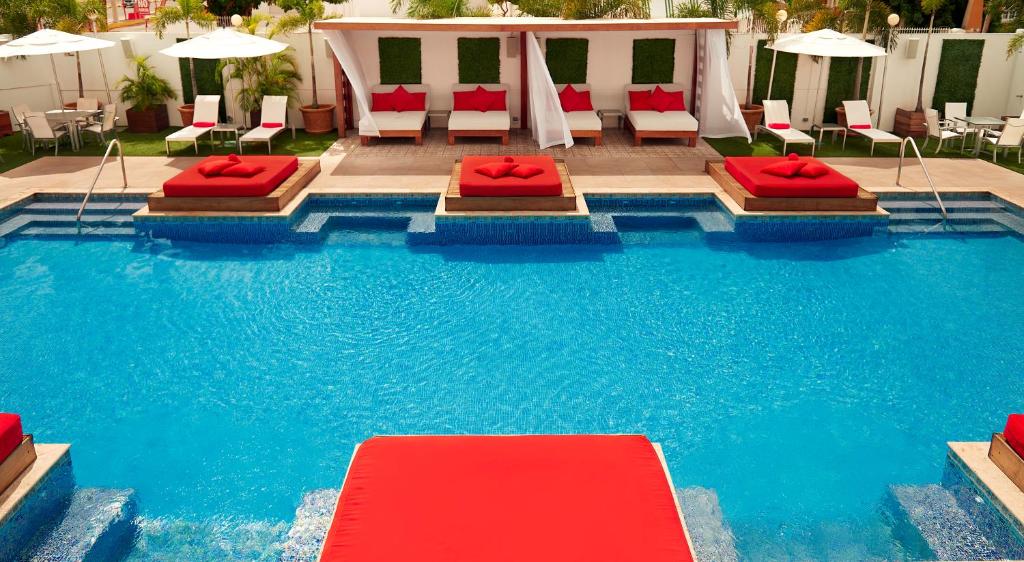 金斯敦S Hotel Kingston的一座带两张床和椅子的游泳池