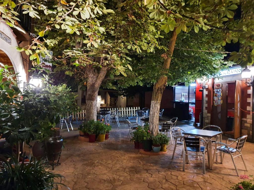 布龙查莱斯西扎酒店的一间设有桌椅和树木的餐厅
