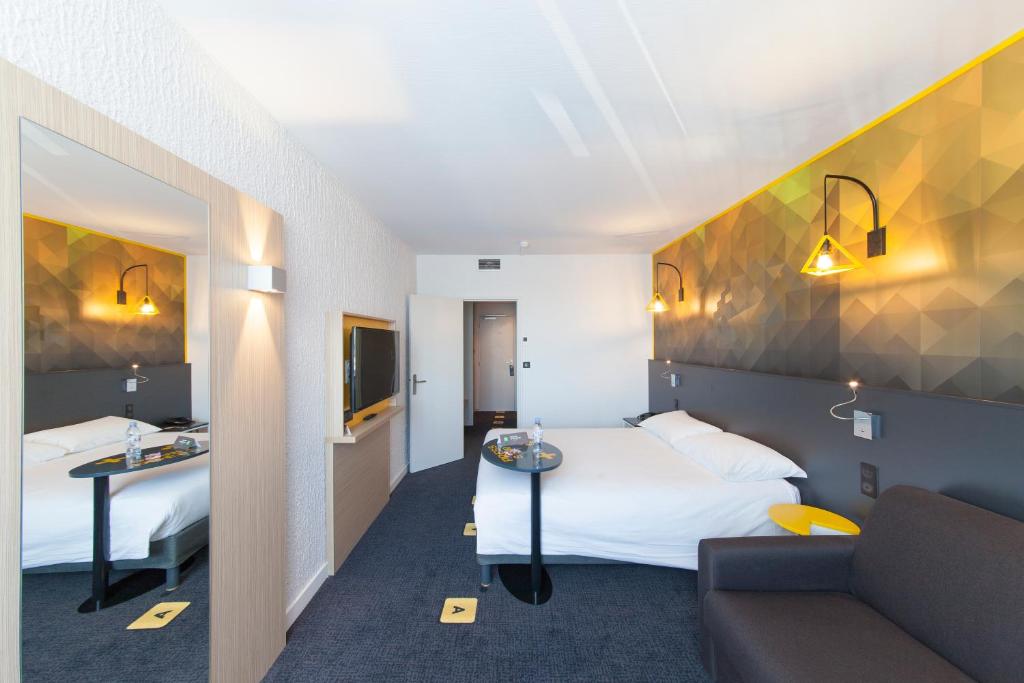 普瓦捷普瓦捷北部宜必思尚品酒店的酒店客房,设有两张床和一张沙发