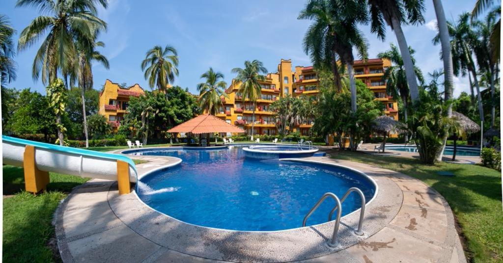 伊斯塔帕普尔它德尔马伊斯塔帕酒店的一座度假村游泳池,其背景是度假村