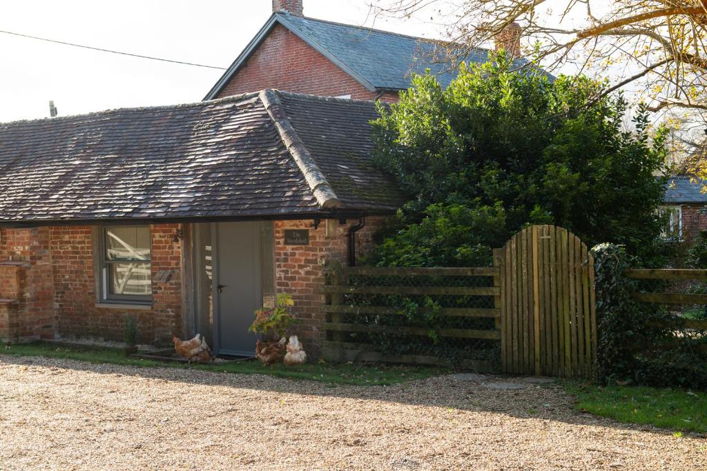 GodshillStreet Farmhouse的一座带木栅栏的小砖屋