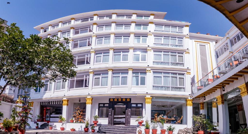 加德满都Durbar Hotel & Residence的一座白色的大建筑,前面有拱门