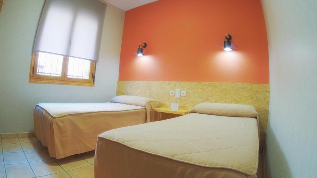 阿尔玛格鲁Hs San Francisco - CÉNTRICO的橙色墙壁的客房内的两张床