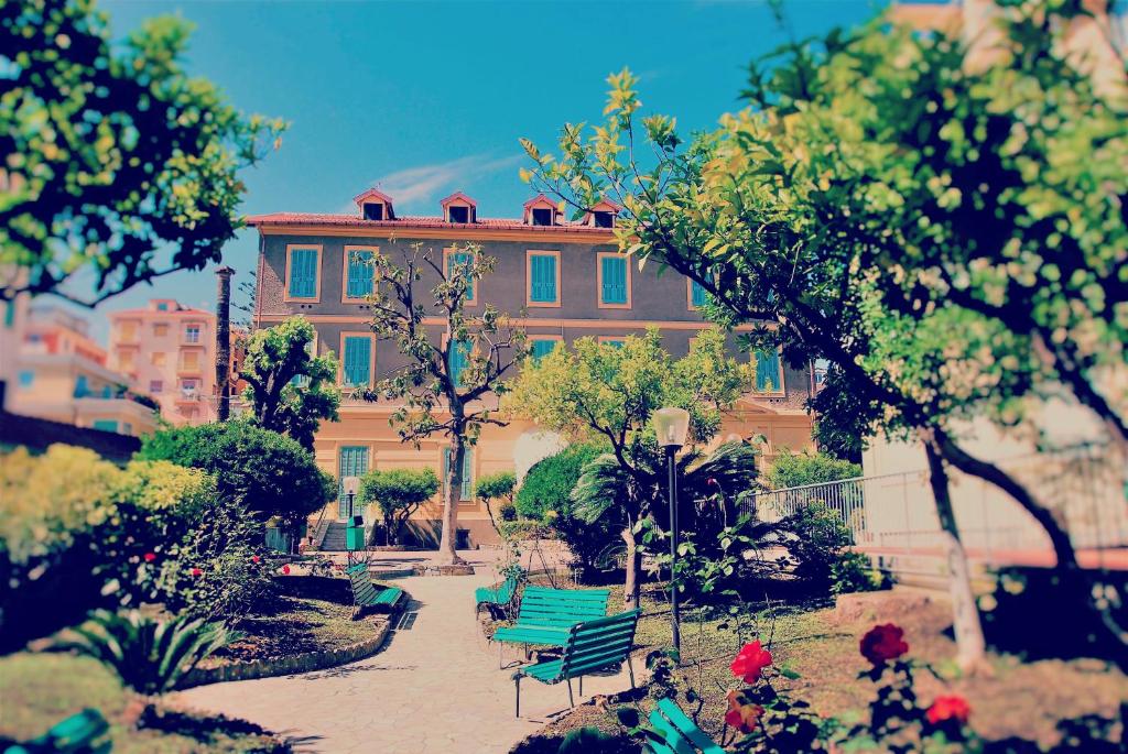 圣雷莫Hotel Villa Sophia的花园中设有绿色长椅的建筑