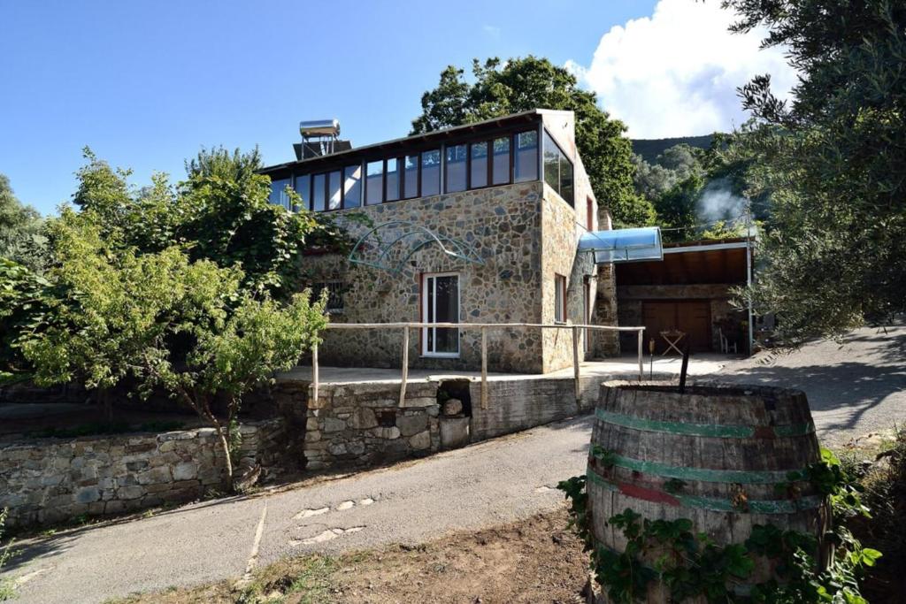 KántanosVilla Areti - A Cottage in the Cretan Nature的前面有桶的石头房子