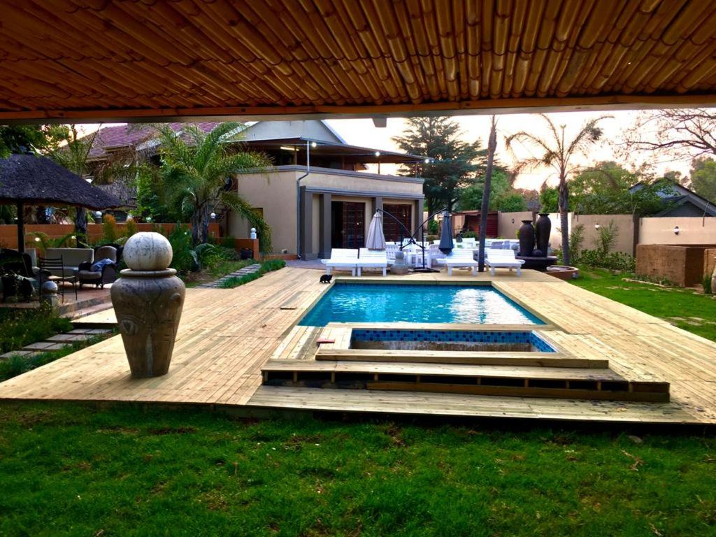 约翰内斯堡The Afropolitan的一个带游泳池和房子的后院