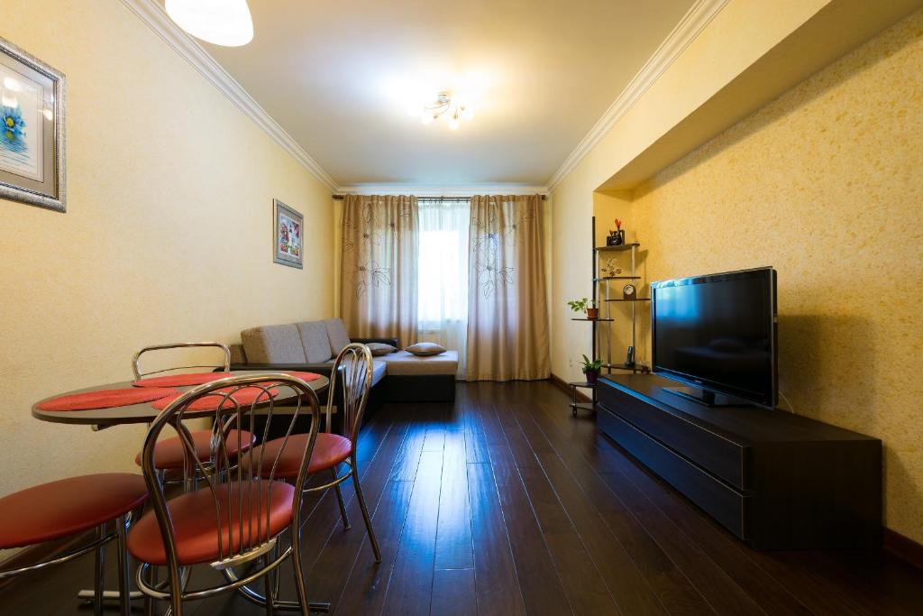 阿拉木图Nadezhda Apartment on Dostyk street 89的客厅配有桌椅和电视