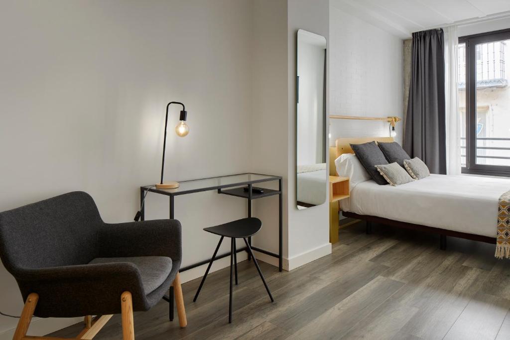 潘普洛纳阿里亚祖旅馆的配有一张床和一把椅子的酒店客房