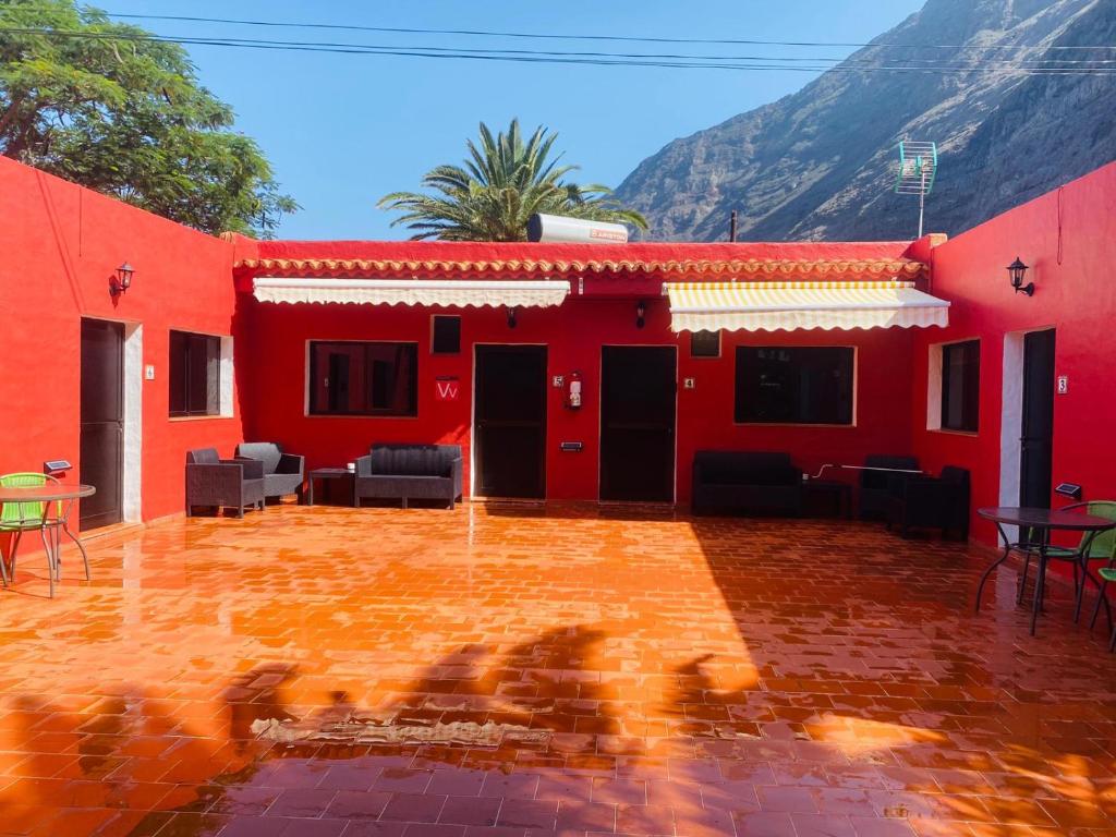弗龙特拉Pensión Casa Trudo的前面有桌椅的红色房子
