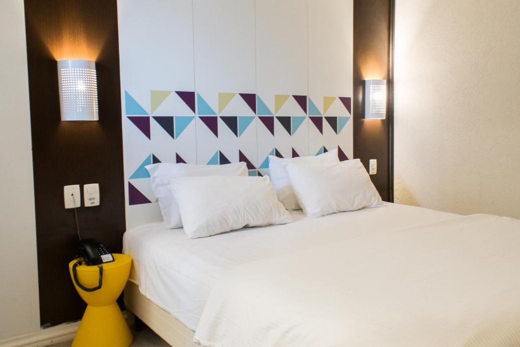 阿雷格里港Master Express Moinhos de Vento的卧室配有白色床和色彩缤纷的墙壁