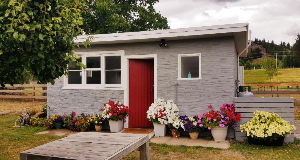 亚历山德拉'The Crib' on Legacy Vineyard的一座小房子,有红色的门和鲜花