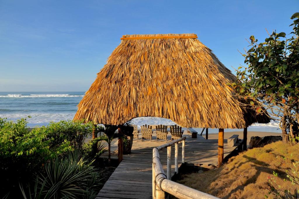 佩达西镇Hotel Posada Los Destiladeros的通往海滩的木道,带草屋