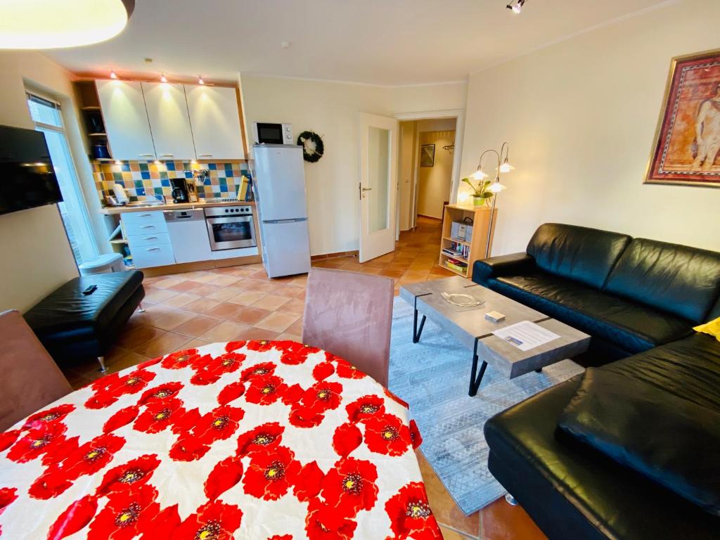 黑灵斯多夫Residenz Bleichröder - Ferienwohnung 11的客厅里设有一张带红色鲜花的桌子