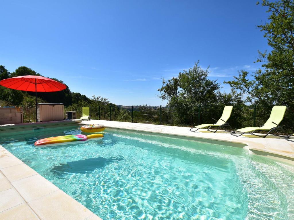 CuzyAttractive holiday home in Cuzy with pool的一个带两把椅子和遮阳伞的游泳池
