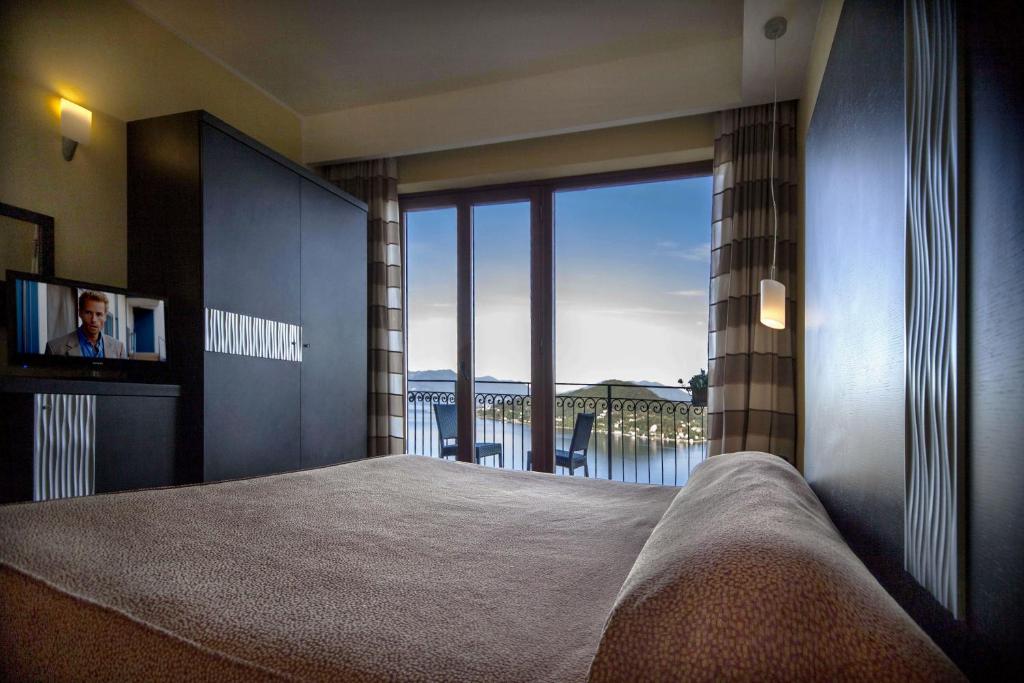 阿罗纳圣卡洛餐厅酒店的一间卧室设有一张床,享有海景