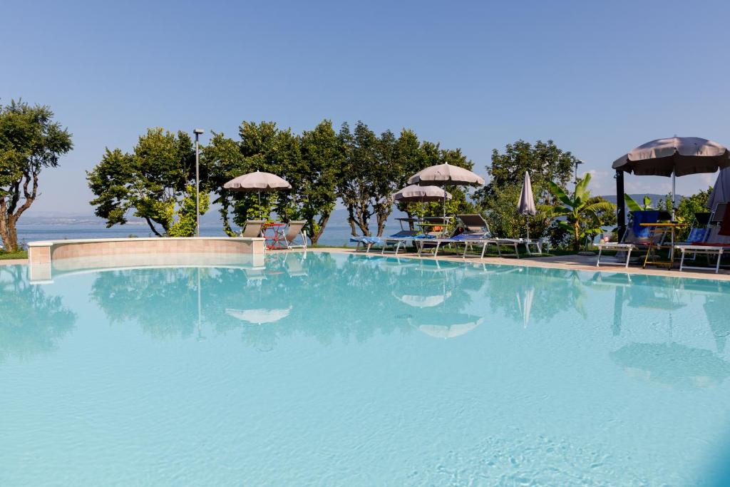 巴多利诺圣马可酒店的一个带椅子和遮阳伞的大型游泳池