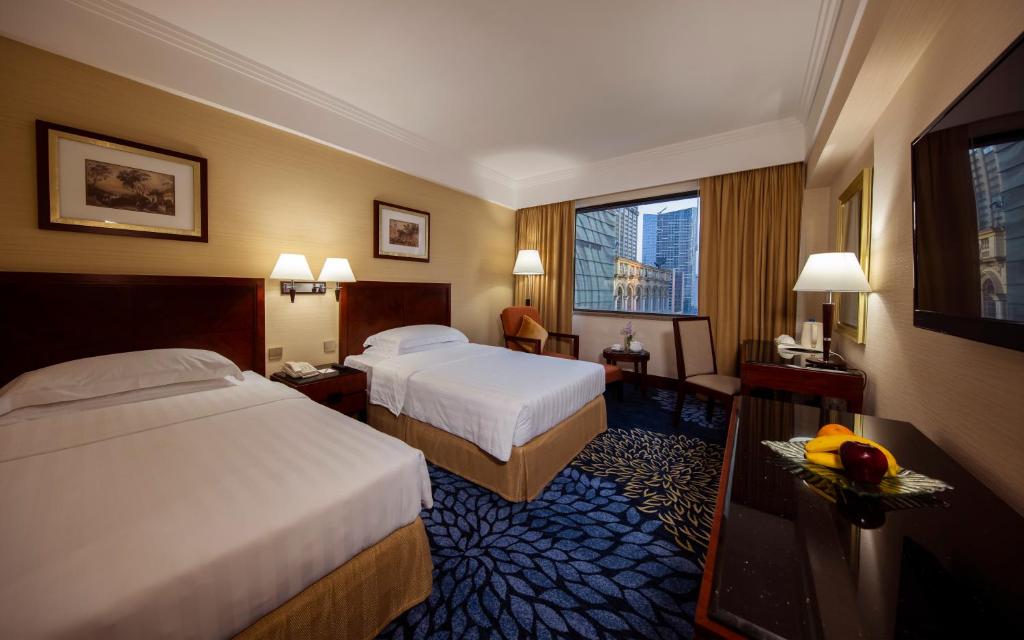 澳门总统酒店的酒店客房设有两张床和窗户。