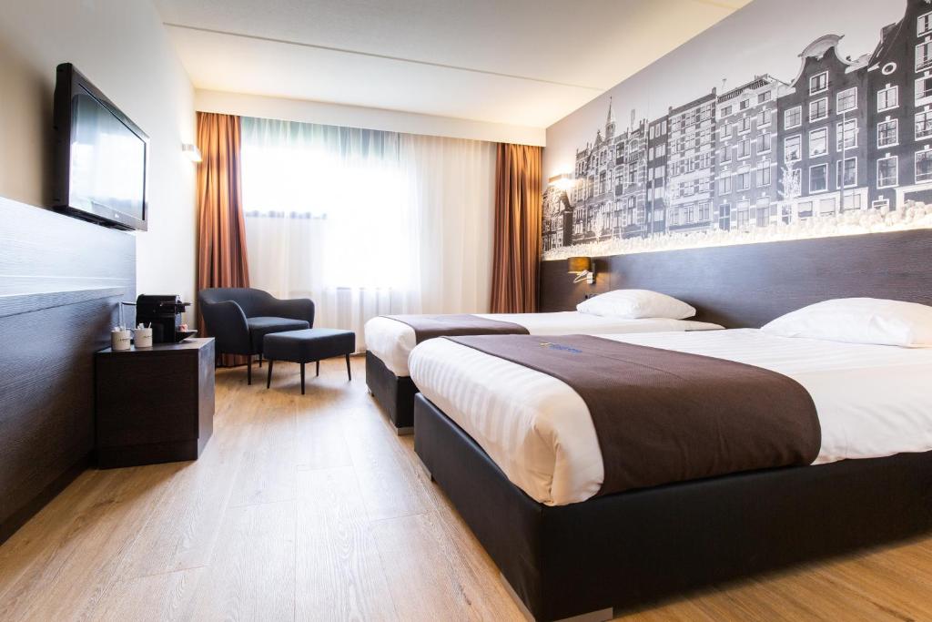 阿姆斯特丹阿姆斯特丹努尔德巴斯蒂欧酒店的酒店客房设有两张床和电视。