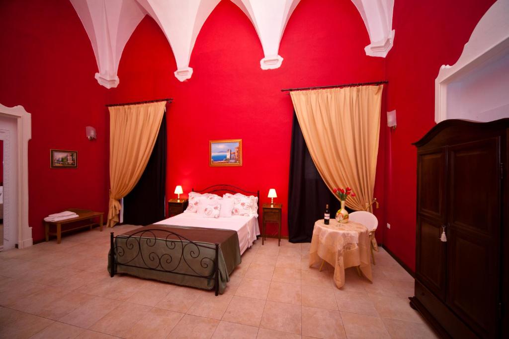 加利波利迪莫拉圣温琴佐住宿加早餐旅馆的卧室设有红色的墙壁、一张床和一张桌子