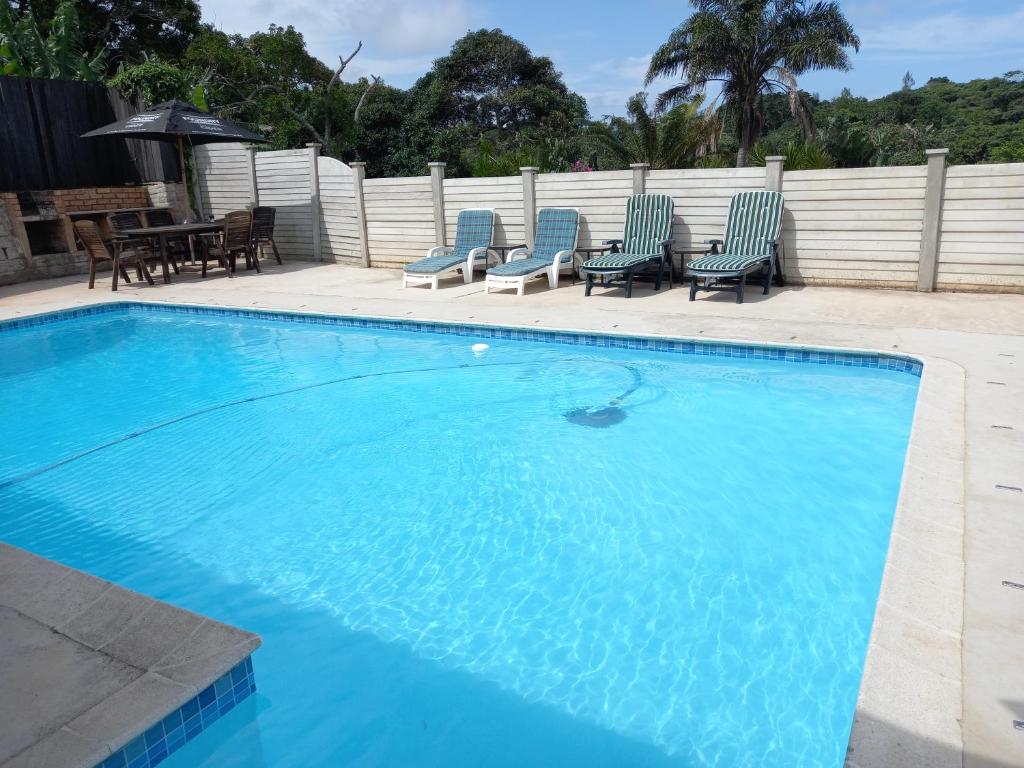 谢普斯敦港Poolside Guest House的一个带椅子和桌子的大型游泳池