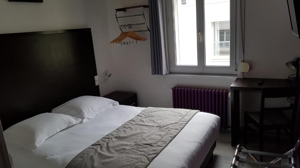 亚眠空间酒店的一间卧室配有一张床、一个窗口和一张书桌