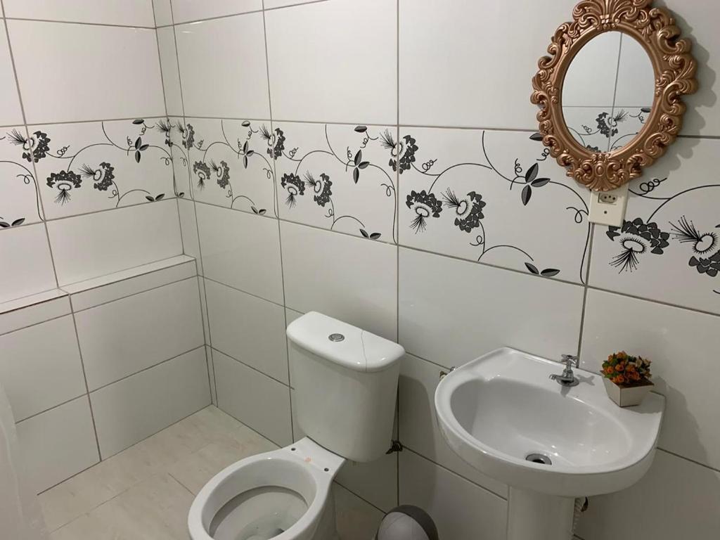 塞蒂拉瓜斯Kitnet - Apart Hotel 3的一间带卫生间、水槽和镜子的浴室