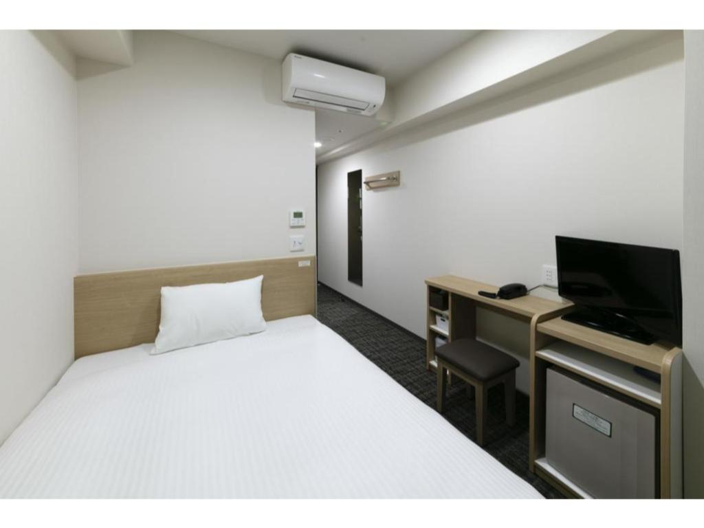 京都R & B Hotel Kyoto Shijo Kawaramachi - Vacation STAY 74220的一间卧室配有一张床和一张书桌及电视