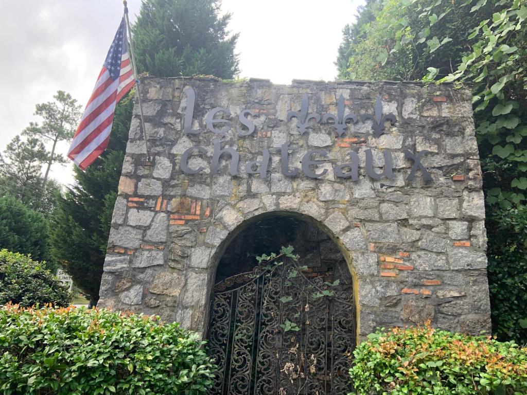 石头山Jackson’s Stone Mountain Hideaway的石墙的大门,有美国国旗
