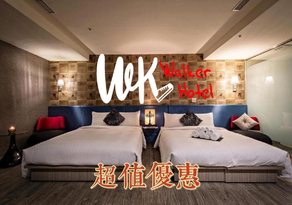 台北沃客商旅正义馆的一张床位,房间标有Uk市场酒店的标志