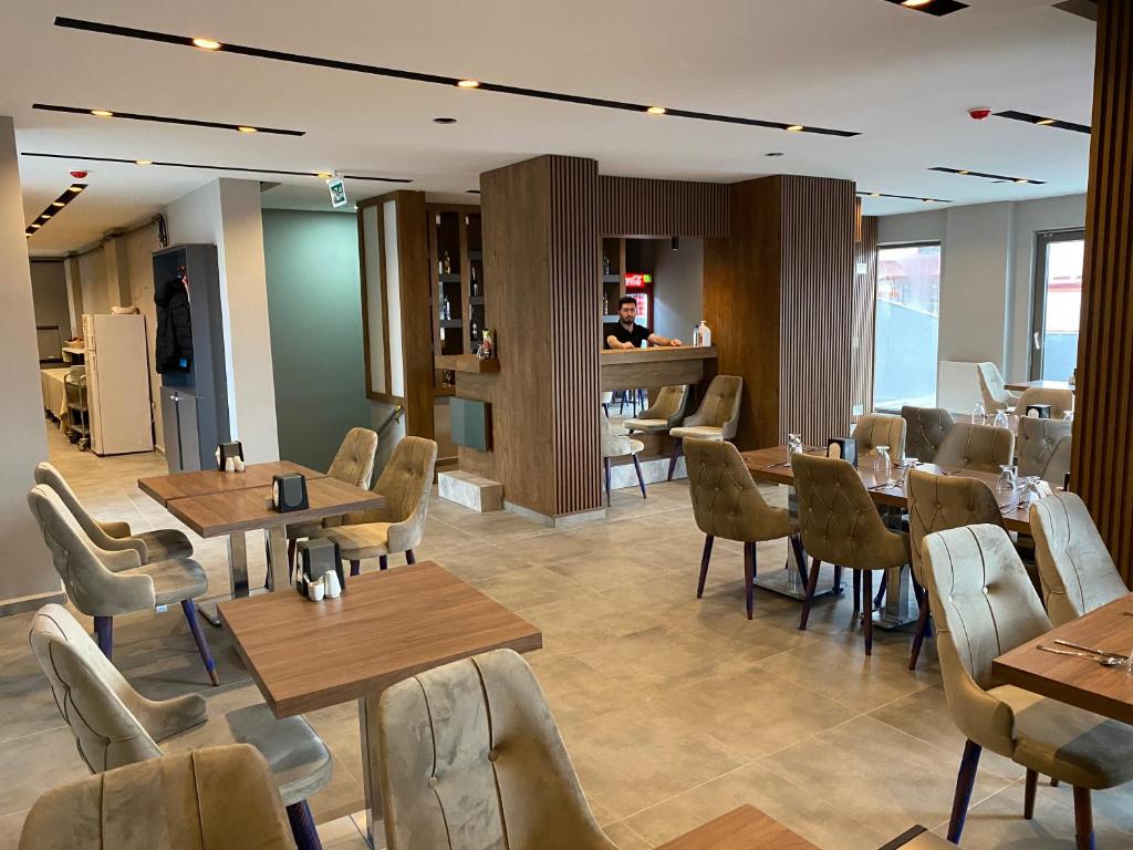 SarıkamısSarıkamış Aras Otel的餐厅设有木桌、椅子和柜台
