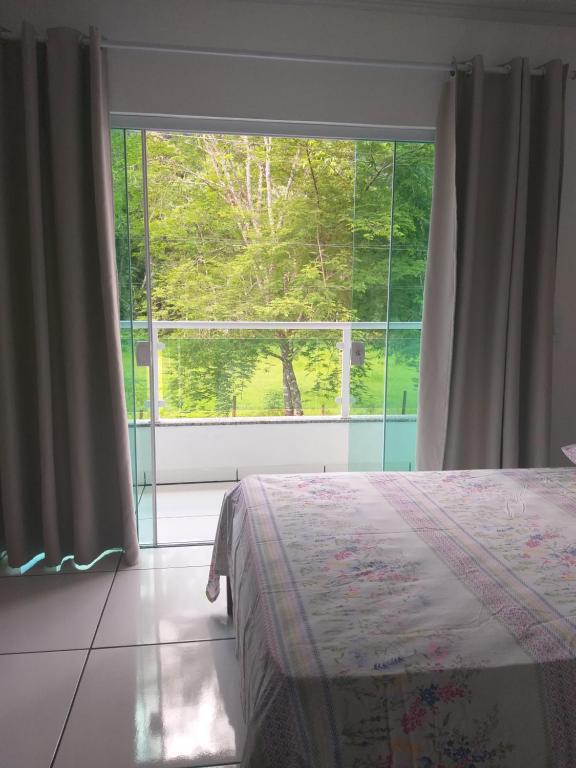 帕拉蒂Casa Aconchegante a 20 Minutos do Centro de Paraty的一间卧室设有一张床和一个大窗户